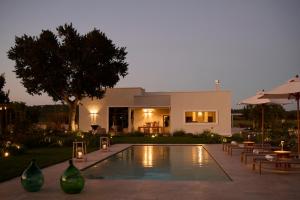 a villa with a swimming pool in front of a house at Tenuta Giotta in Castellana Grotte
