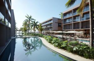 a resort swimming pool with palm trees and a hotel at Porto Alto Resort in Ipojuca