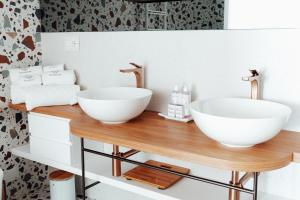 a bathroom with two sinks on a wooden counter at Albergo Dipinto BaccoFurore in Furore