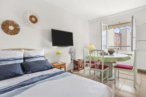 Un dormitorio con una cama, una mesa y un televisor. en Appartement à 200 M De La Mer, en Fréjus