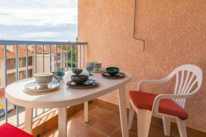 - Balcón con mesa blanca y sillas en Appartement à 200 M De La Mer, en Fréjus