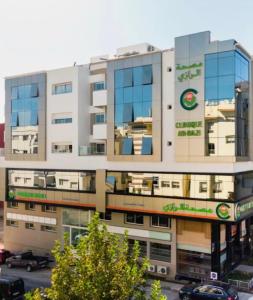 a large white building with windows and a parking lot at Appartement duplex très chic in Ville Nouvelle