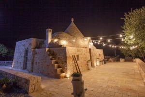 ein Steingebäude mit Lichtern in der Nacht in der Unterkunft Trullo Oasi Santo Stefano - private pool in Castellana Grotte