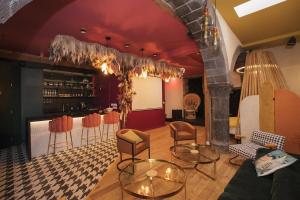 a room with chairs and tables and a bar at Suite haut de gamme pour couples in Clermont-Ferrand