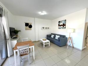 a living room with a blue couch and a table at COSTA AZUL APARTMENTS -1A in Puerto de Mogán