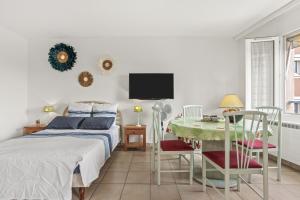 una camera da letto con un letto, un tavolo e una TV di Appartement deux pas de la Mer a Fréjus