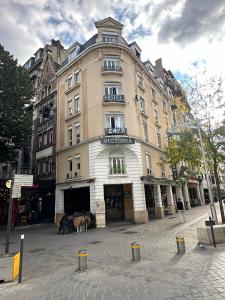 a large building on the corner of a street at Hôtel Victoria in Reims