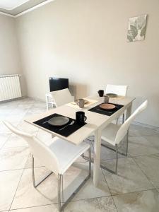 a table with white chairs and a white table with plates on it at Il Cantuccino in Montecatini Terme