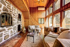 un salon avec une cheminée en pierre et des canapés dans l'établissement Chalet Suisse, SPA, Billard, Ski et Montagne, à Sainte-Agathe-des-Monts 54 autres photos