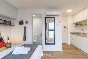 a bedroom with a bed and a sink and a mirror at RUP - Equipped Studios in Building with Pool in Blumenau +103 photos