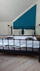 a bedroom with a black bed with a blue headboard at Rheinsteig-Ferienwohnungen in Kaub