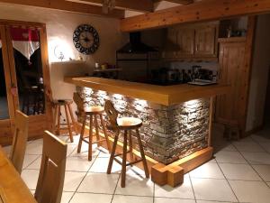 a kitchen with a stone counter and bar stools at Chalet les Champerons - Entre Lacs et Montagne in Marthod