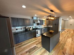 a large kitchen with blue cabinets and a island in it at Pleasant Lake Bed and Breakfast in Osceola