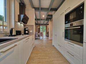 a kitchen with white cabinets and a stove top oven at Kiebitz 317 in Mirow