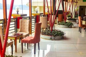 ein Restaurant mit Stühlen und Pflanzen in einem Raum in der Unterkunft Hotel New Riviera bukavu in Bukavu