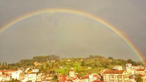 a rainbow in the sky over a city at Apartamento Arcoiris in Betanzos