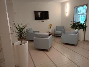 a waiting room with chairs and a tv on a wall at Hotel Riviera in Silvi Marina