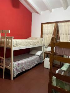 ein Zimmer mit zwei Etagenbetten und einer roten Wand in der Unterkunft Home Sweet Hospedaje Temporal in Cordoba