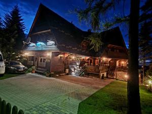 a log cabin at night with lights on it at Bukovina Concept obok stoku i basenów termalnych in Bukowina Tatrzańska