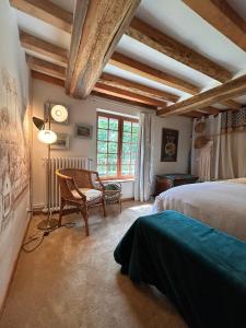 a bedroom with a bed and a chair and a window at Le Domaine de Blanvatel in Sainte-Marguerite-de-Viette +62 photos
