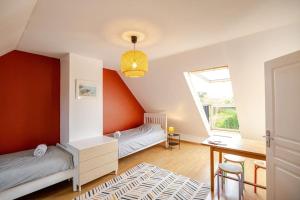 a bedroom with two beds and a desk and a window at Maison familiale 11 couchages, proche de La Palue in Crozon