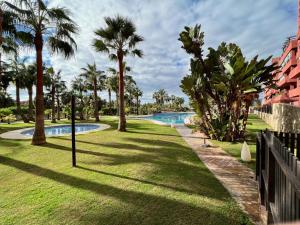 un parque con palmeras y una piscina en PUSHE Playa Granada Beach & Golf 8, en Motril