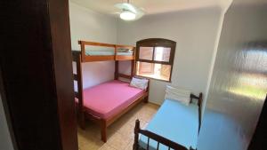a small room with two bunk beds and a window at APTO 8 PESSOAS PRAIA TENÓRIO 7 min a pé in Ubatuba