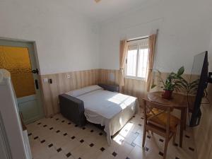 a bedroom with a bed and a table and a window at Calle Yelmo de Mambrino 19 in Campo de Criptana