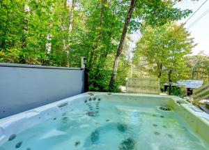 a jacuzzi tub in a yard with trees at Chalet Douce Evasion St Adolphe in Morin Heights +61 photos