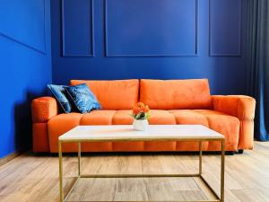 an orange couch in a living room with a coffee table at Indigo Royale apartman Borovi in Divčibare