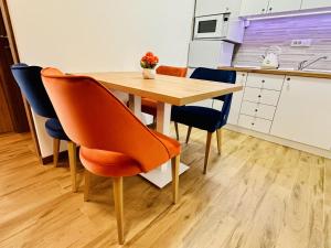 a kitchen with a wooden table and chairs at Indigo Royale apartman Borovi in Divčibare