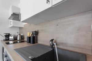 una cucina con lavello e fornello di L'Eden - Quiet - Parking - WIFI - Beach a Antibes