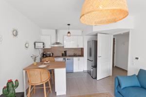 una cucina e un soggiorno con divano blu di L'Eden - Quiet - Parking - WIFI - Beach a Antibes Altre 25 foto