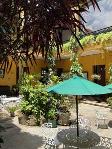 a table and chairs with an umbrella in a courtyard at Hotel Spring in Guatemala