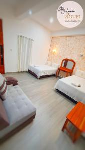a room with three beds and a table and chairs at Hotel Betania in Jaén