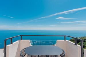 a bench on a balcony with the ocean in the background at Albergo Dipinto BaccoFurore in Furore