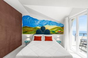 a bedroom with a white bed with a painting on the wall at Albergo Dipinto BaccoFurore in Furore