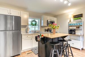 una cucina con mobili bianchi e un frigorifero in acciaio inossidabile di Downtown Heflin Cottage with Deck and Fire Pit! a Heflin
