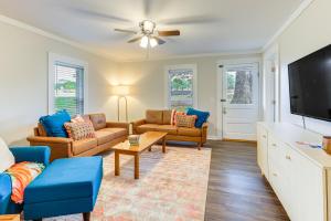 un soggiorno con divani e TV a schermo piatto di Downtown Heflin Cottage with Deck and Fire Pit! a Heflin