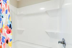 un bagno con tenda da doccia e lavandino di Downtown Heflin Cottage with Deck and Fire Pit! a Heflin Altre 16 foto