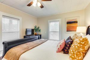 una camera da letto con un letto e un ventilatore a soffitto di Downtown Heflin Cottage with Deck and Fire Pit! a Heflin
