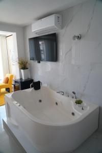a white bath tub in a white bathroom at Hotel Betania in Jaén +42 photos