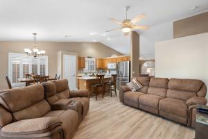a living room with two couches and a kitchen at Sunny Home with Backyard Oasis in San Tan Valley! in Queen Creek