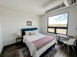a bedroom with a bed and a large window at Sleepover 1BD 1BA Des Moines Apartments in Des Moines