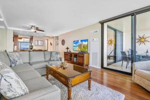 una sala de estar con un sofá y una mesa en Mahana 1107, en Kahana
