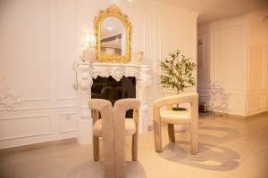 una stanza con camino con due sedie e uno specchio di Vanity Villa Luxe Residence Ikoyi a Lagos Altre 37 foto