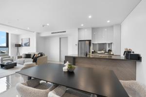 a kitchen and living room with a table and chairs at The Ocean - Beachfront 72F 3Bedroom Skyhome Ocean Views with Parking & Resort Facilities in Gold Coast
