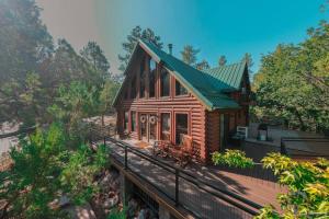 una pequeña casa de madera con techo verde en Charming Log AFrame in Pine, en Pine