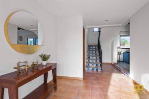 a hallway with a table and a mirror on the wall at El Centenario Fully-equipped Home Steps to Beach in El Centenario +22 photos