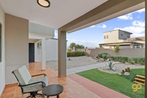 a house with a porch with a chair and a yard at El Centenario Fully-equipped Home Steps to Beach in El Centenario